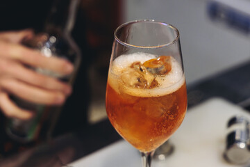 Barman mixing liquor beverages and alcohol drinks in plastic cups, bartender working, beautiful row line of different coloured cocktails on open air summer party in a bar, catering on banquet event