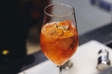 Barman mixing liquor beverages and alcohol drinks in plastic cups, bartender working, beautiful row line of different coloured cocktails on open air summer party in a bar, catering on banquet event