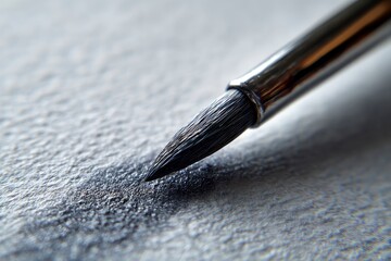 A close-up image showcases a paintbrush depositing black pigment onto a textured white surface