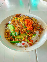 Vietnamese grilled pork with vermicelli noodles, topped with peanuts, herbs, cucumber, and chili paste—fresh, bold, and full of flavor