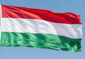 Obraz premium National flag of hungary waving proudly in the wind against a clear blue sky.