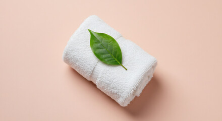 Luxurious white spa towel with fresh green leaf signifies natural wellness and serene relaxation, perfect for beauty.