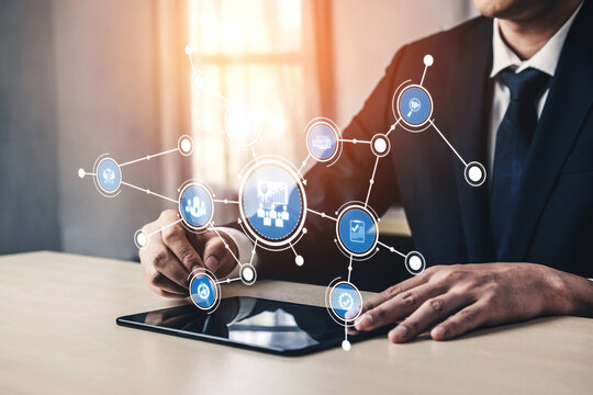 A business professional interacts with a digital tablet, showcasing various network symbols that represent technology and innovation in a modern office environment. Tessel