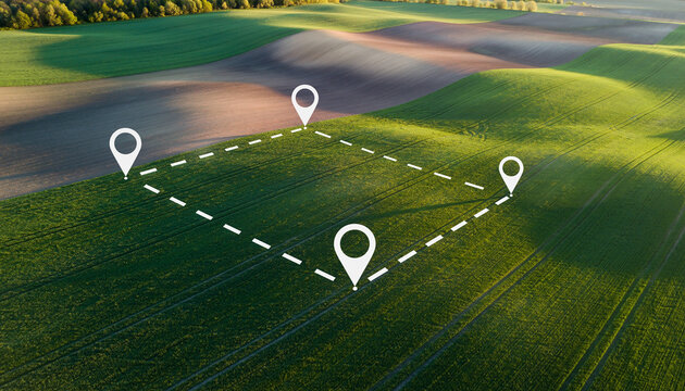 Aerial view of green farmland with GPS location pins marking a plot of land.
