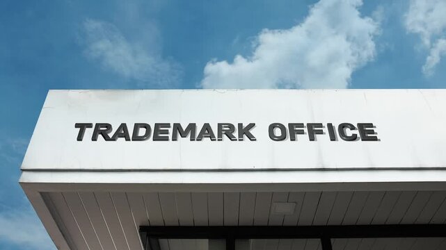 Trademark Office word sign displayed on a governmental or legal building under a clear blue sky, symbolizing intellectual property, brand registration, legal protection, business law, and commercial