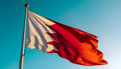 Bahrain's vibrant flag dances in the wind against a bright blue sky, a symbol of national pride and global connection, perfect for travel or cultural projects