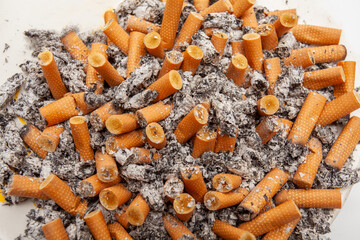 Ashtray full of cigarette butts and ash concept