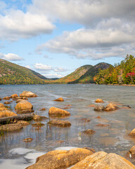 Autumn scenes at Jordan Pond with rocks at foreground