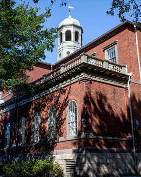 Harvard Hall at Harvard University surrounded by trees and under blue sky