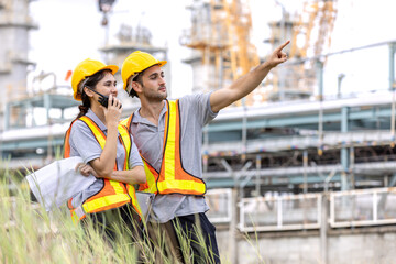 Engineers male, female working with tablet in industry oil refinery oil, gas refinery background,...