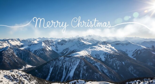 Snowy mountain range under a bright blue sky with "Merry Christmas" written in the sky by a plane leaving a vapor trail for a festive holiday season greeting