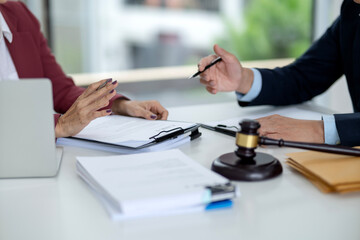 Legal professionals discuss important documents contract agreement case negotiation modern office setting justice gavel table