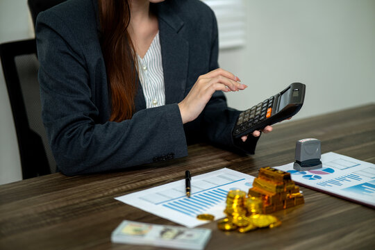Adult Asian businesswoman professional calculates finance analyzes data for business strategy investment wealth growth at modern office desk workspace