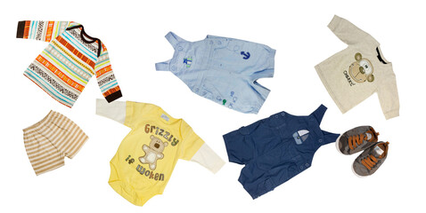 playful isolated scatter of assorted baby boy apparel, including graphic print bodysuits, brightly patterned tops, denim shortalls, striped shorts, and toddler sneakers.