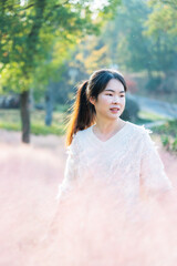 Young woman standing in pink flowering plants outdoors