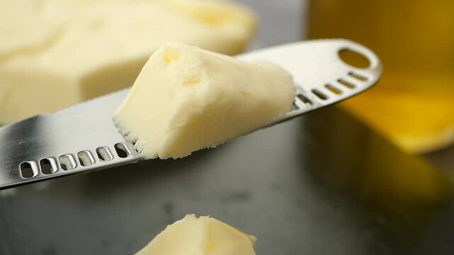 Perfectly spreadable butter on a knife in kitchen setting