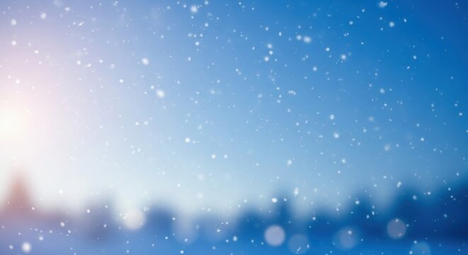 Falling snow against a blue winter sky with blurred background and sparkling light