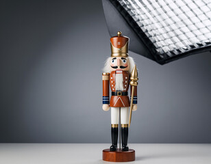 Nutcracker soldier stands tall on white surface in studio lighting, showcasing intricate details and festive holiday spirit.