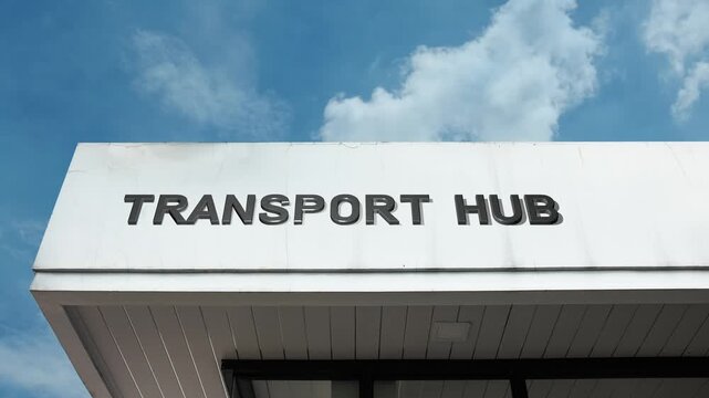 Transport Hub word sign displayed on a large transportation building under a clear blue sky, symbolizing public transit, logistics, travel, infrastructure, urban connection, and intermodal movement