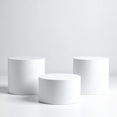 Three white, cylindrical pedestals on a light surface