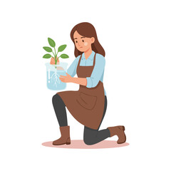 Young woman in apron kneeling holding a small plant in a clear container.
