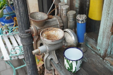 Vintage Manual Meat Grinder and Enamel Mug on Wood Table