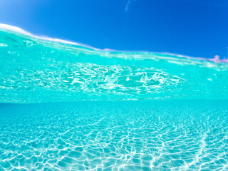 嘉比島の白砂ビーチの半水面撮影。観光客やパラソル、テントが見える。美しいサンゴ礁と熱帯魚の群れ。 安室島沖縄県 島尻郡慶良間諸島座間味島-2025 サンゴの産卵があり卵が漂う。沖縄本島から40km西方の諸島。30以上の島嶼群全体が国立公園に指定。珊瑚礁の青い海と白い砂浜は世界屈指の美。貴重な動植物が多数生息。 