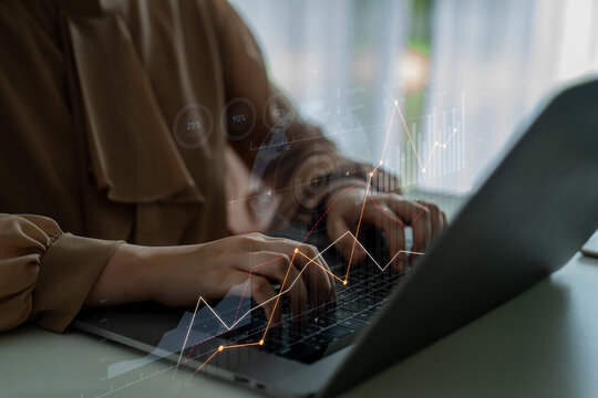 A professional woman engaged in work on her laptop, with a digital overlay of financial graphs and data, symbolizing modern business analysis and investment strategies. Scalp - Powered by Adobe