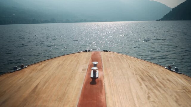 Static shot of a wooden speed boat navigating over blue water at Lake Iseo, Italy (Lago d&rsquo;Iseo), near Montisola, Isola di Loreto, and Isola di San Paolo