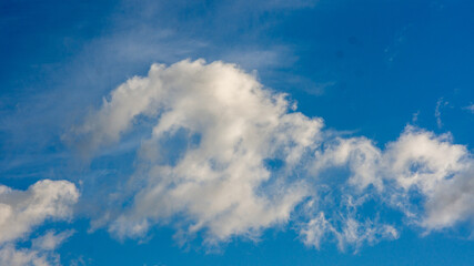 Bright Blue Sky Adorned with Majestic White Cumulus Clouds on a Clear Sunny Day, Showcasing Nature's Serene Beauty and Atmospheric Patterns