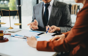 Business and lawyers discussing contract papers with brass scale on desk in office. Law, legal services, advice,  justice and law concept .