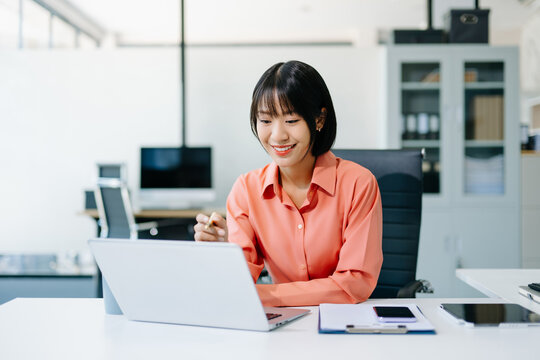 Business woman using tablet and laptop for doing math finance on an office desk, tax, report, accounting, statistics, and analytical research concept in office