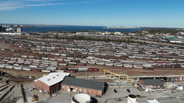 Norfolk Virginia port rail yard and freight cars with Hampton Roads harbor 4k aerial drone video