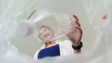 Fototapeta premium Sustainability. Woman recycling plastic bottle, promoting eco-friendly habits.