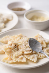 Farfalle pasta with white cream cheese sauce and black pepper, Italian food on a white plate