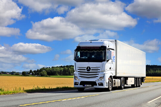 White Mercedes-Benz Actros Truck Semi FRC Trailer on Road on a Sunny Day of Spring. Copy Space. 