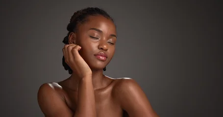 Fotobehang Badkamer Black woman, skincare and beauty with glow in studio for cosmetics on a dark background. Female person, model or relax with makeup, shine or spa for skin treatment or cosmetology on mockup space  © peopleimages.com