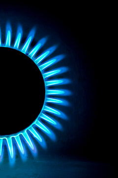 a hundred dollar bill on a gas burner with a burning fire on a black background, the front and back background is blurred with a bokeh effect