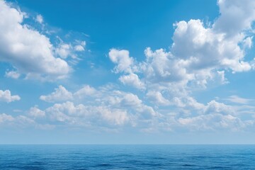 Obraz premium Blue ocean under a sky with fluffy white cumulus clouds