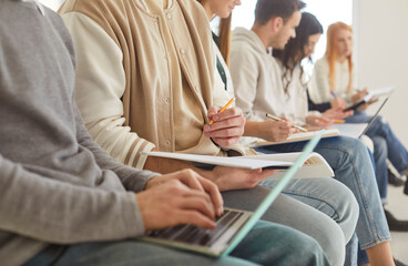 Business people or students working and learning together in office, using laptops and documents,...