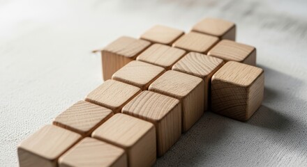 Obraz premium Wooden cubes arranged in arrow shape on neutral surface
