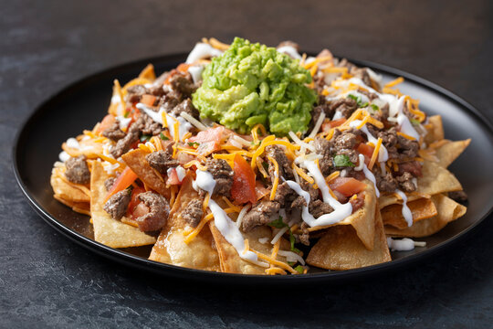 Carne Asada nachos on a black plate 