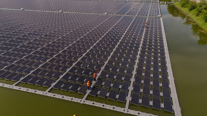 Professional workers clean and inspect solar panels on a floating buoy. Power plant with water	