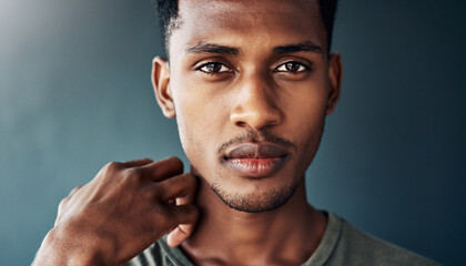 Close-up portrait of a young man with dark skin and short hair.