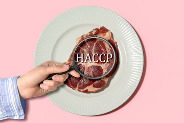Plate with fresh raw steak on pink background