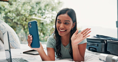 Happy woman, wave or video call with phone in bed for travel, vacation or accomodation in hotel. Female person, traveler or tourist with smile, mobile smartphone or suitcase for chat, app or check in