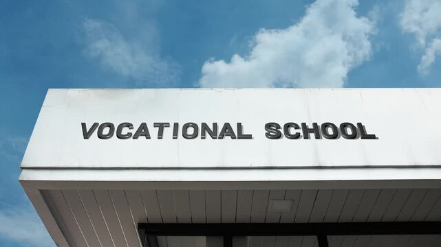 Vocational School word sign displayed on an educational building under a clear blue sky, symbolizing technical training, career education, skill development, practical learning, trade skills