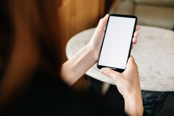 Close-up of woman holding smartphone with white screen, perfect for mobile app mockup, technology, digital communication, and online lifestyle concept.