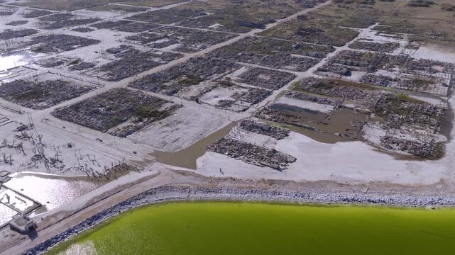 Aerial perspective on green water, with high salinity and algae with specific bacteria adapted and bleached grid ruins of Villa Epecu&eacute;n, revealing mineral impact on the flooded Argentine spa town