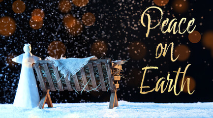 Fototapeta premium Manger with baby Jesus and angel on snow against dark background